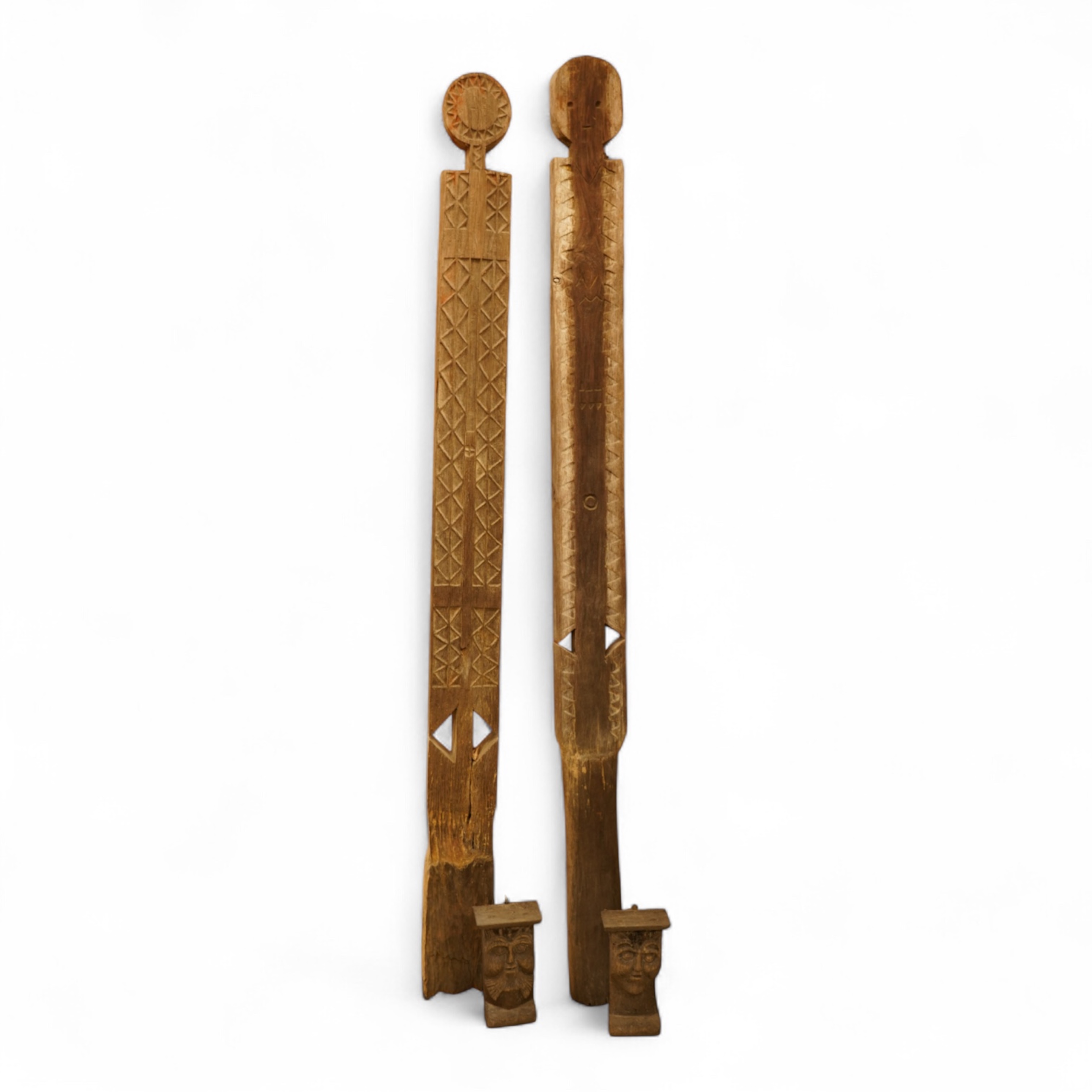 Two African carved wood ancestor figures, tallest 171cm, with two European carved mask capitals